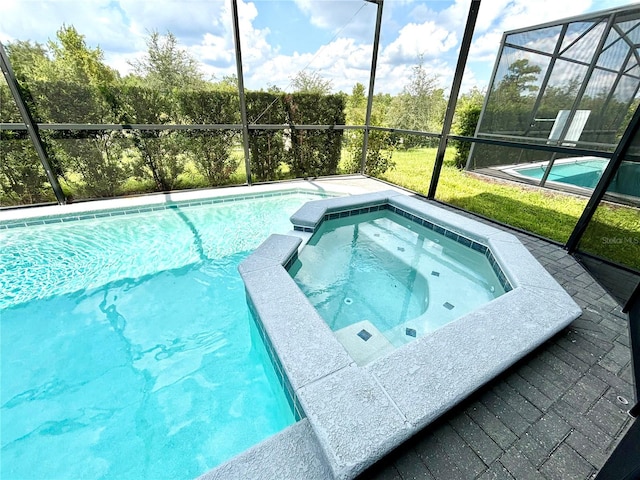 view of pool with an in ground hot tub and a lanai