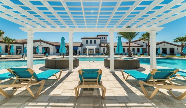 view of patio with a pergola and a swimming pool with hot tub