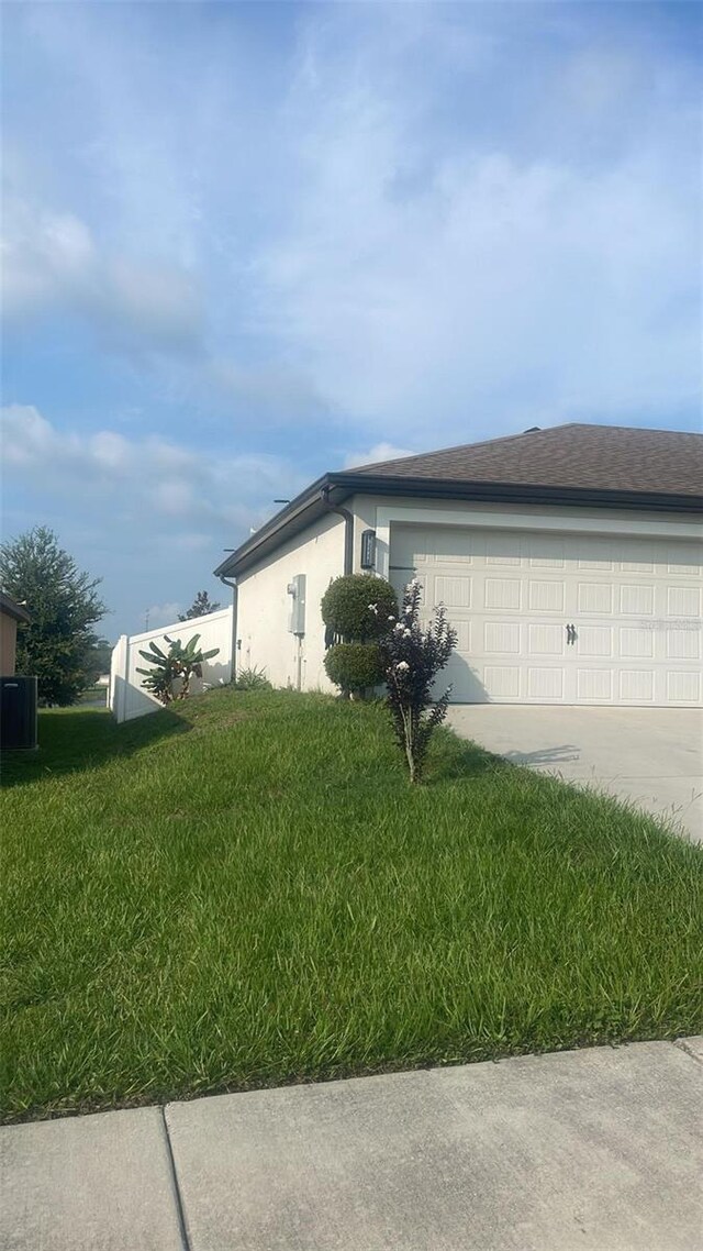 view of property exterior with a garage and a yard