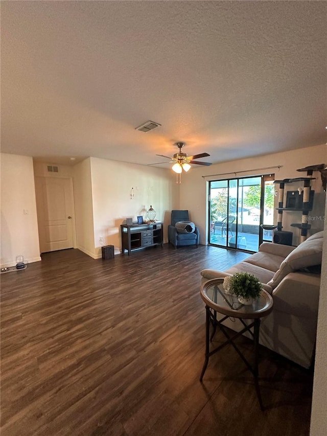 living area featuring a textured ceiling, visible vents, and wood finished floors