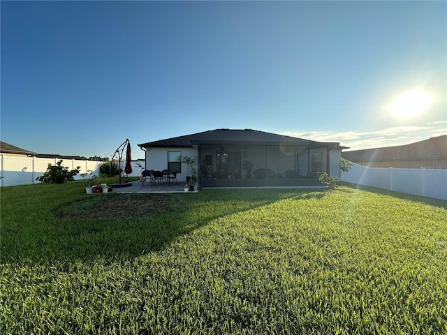 back of property featuring a yard, a fenced backyard, and a patio