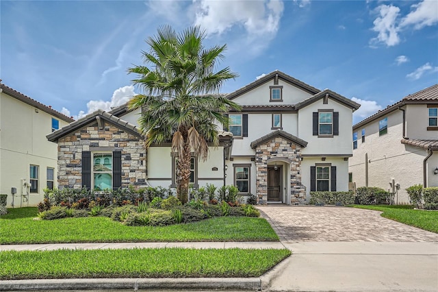 view of front facade with stone siding, a front yard, and stucco siding