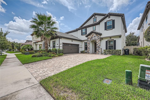 view of front of home featuring decorative driveway, a front yard, stone siding, and stucco siding