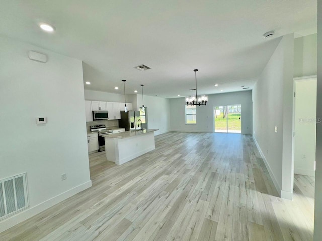 unfurnished living room with light hardwood / wood-style floors, sink, and a chandelier