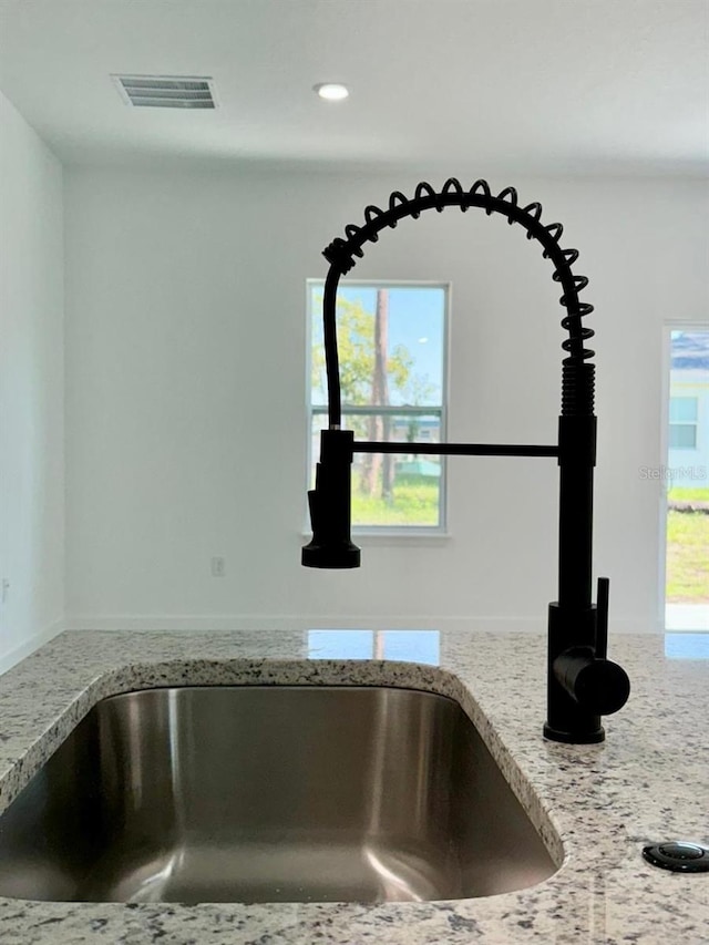 interior details with sink and light stone countertops