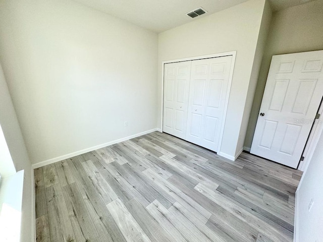 unfurnished bedroom featuring light hardwood / wood-style floors and a closet