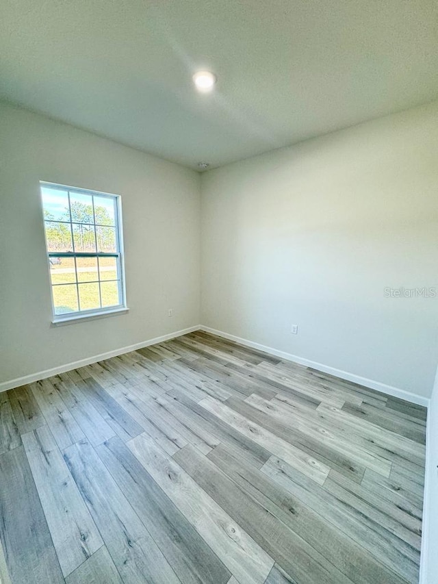 unfurnished room featuring a textured ceiling and light hardwood / wood-style floors