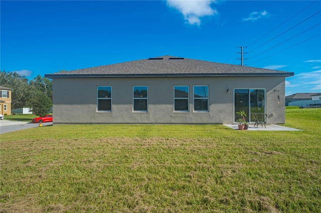 back of house featuring a patio area and a lawn