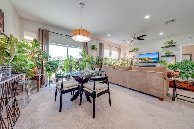 carpeted dining space with ceiling fan