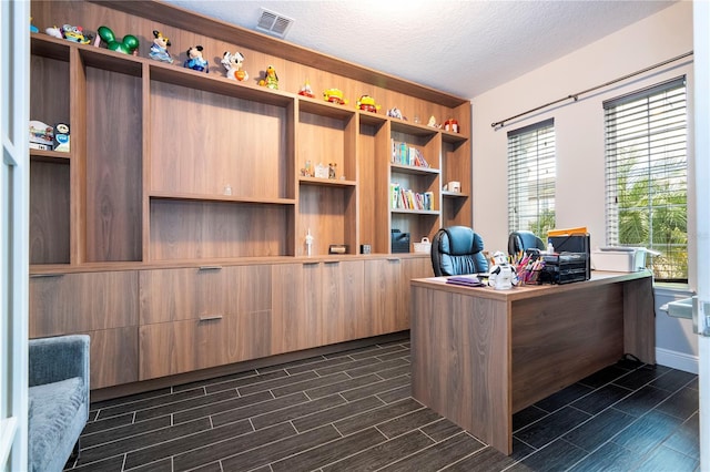 office space featuring a textured ceiling, visible vents, and wood tiled floor