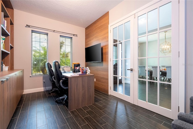 office area with a textured ceiling, wooden walls, a notable chandelier, baseboards, and wood tiled floor