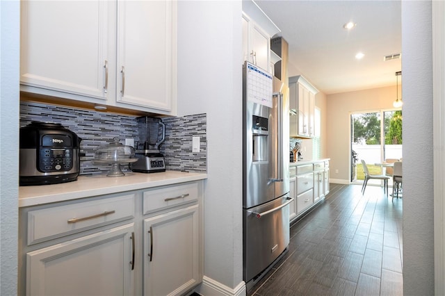 kitchen featuring visible vents, white cabinets, decorative backsplash, dark wood-type flooring, and high end fridge