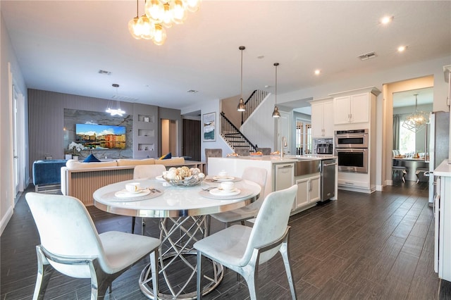 dining space with a chandelier, recessed lighting, dark wood-style flooring, visible vents, and stairway