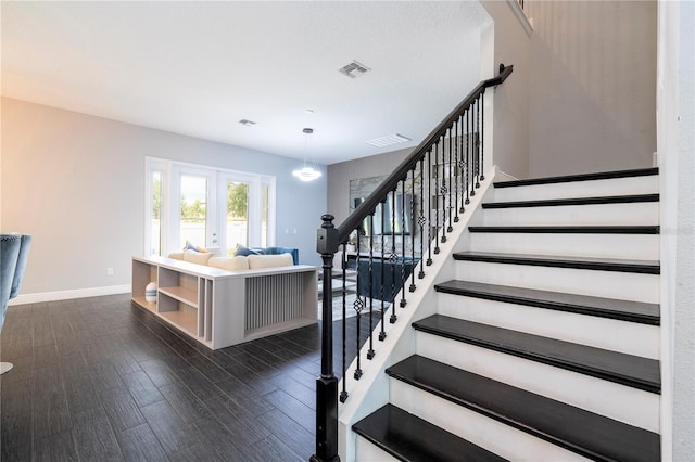 staircase featuring baseboards, visible vents, wood finished floors, and french doors