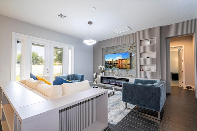 living area with dark wood-style floors, french doors, visible vents, and built in features