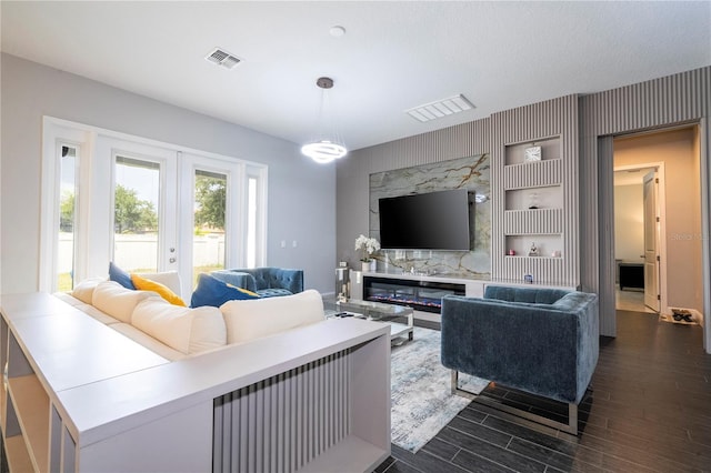 living area featuring visible vents, dark wood-style flooring, and french doors