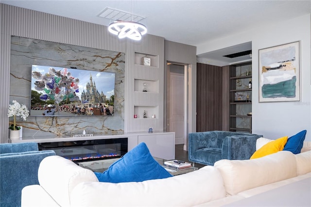 living room featuring built in shelves and a glass covered fireplace