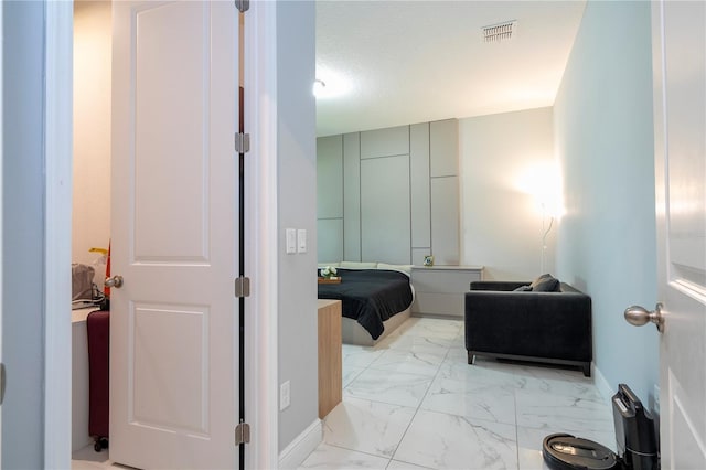 bathroom featuring marble finish floor, visible vents, a textured ceiling, and baseboards