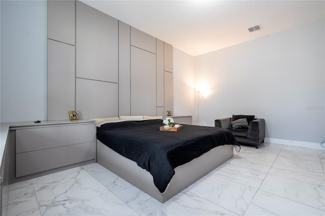 bedroom with marble finish floor, baseboards, visible vents, and a textured ceiling