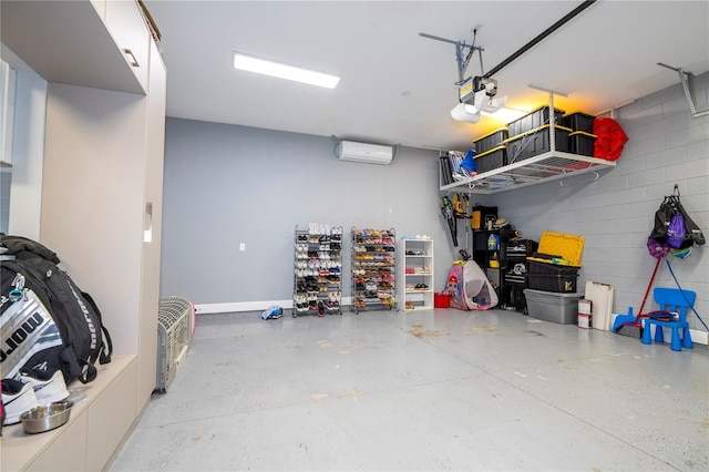 garage with concrete block wall, a garage door opener, and a wall mounted AC