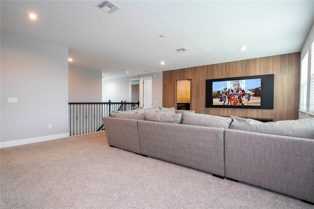 carpeted living area with recessed lighting, visible vents, an accent wall, wood walls, and baseboards