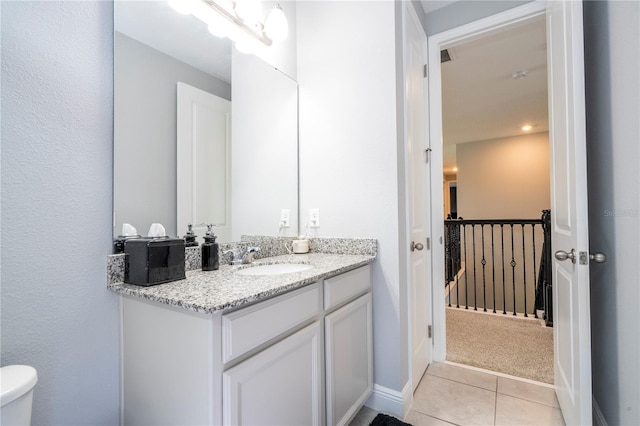 bathroom featuring baseboards, toilet, vanity, and tile patterned floors