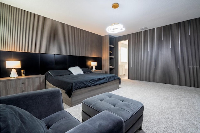 bedroom with connected bathroom, visible vents, and carpet flooring