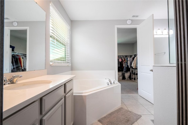 full bath with visible vents, a spacious closet, vanity, tile patterned flooring, and a bath