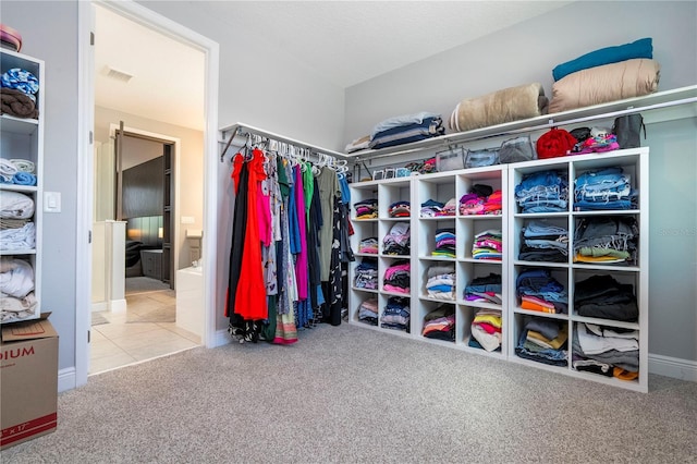 walk in closet with carpet, tile patterned flooring, and visible vents