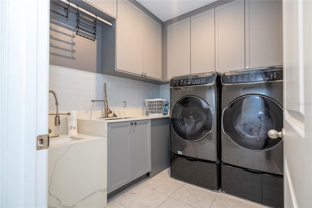 laundry room featuring separate washer and dryer, light tile patterned flooring, a sink, and cabinet space