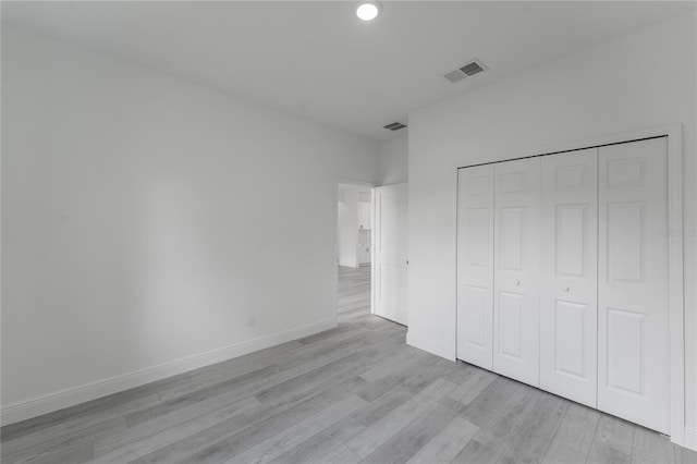 unfurnished bedroom with a closet and light hardwood / wood-style flooring