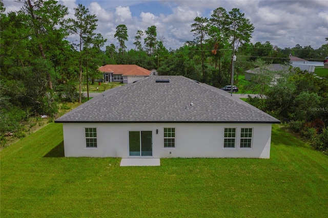 rear view of property featuring a lawn