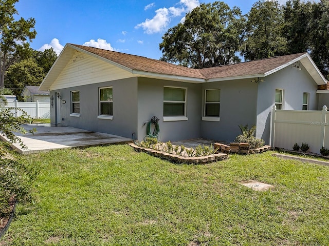 back of house with a lawn and a patio area