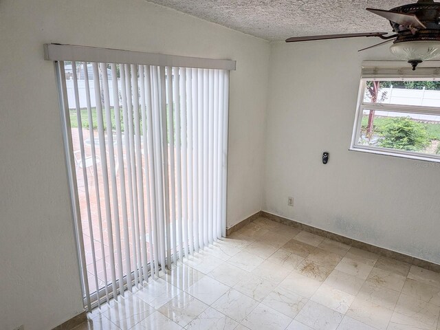 tiled spare room featuring ceiling fan and a textured ceiling