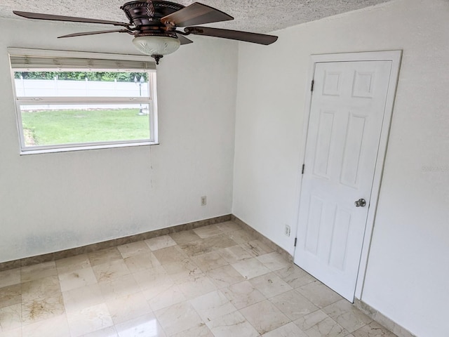 empty room featuring ceiling fan and light tile patterned floors