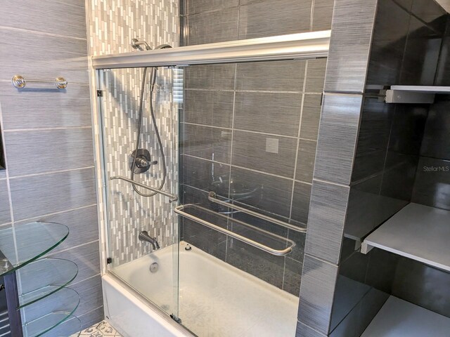 bathroom featuring tile walls and enclosed tub / shower combo