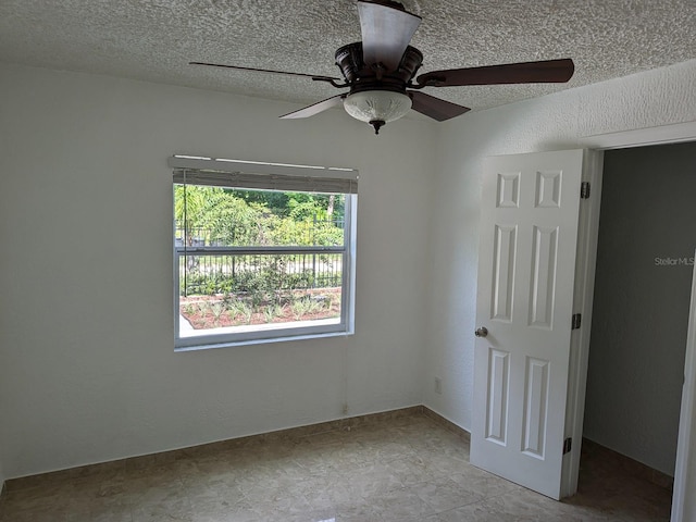 unfurnished bedroom with ceiling fan, a textured ceiling, and light tile patterned floors