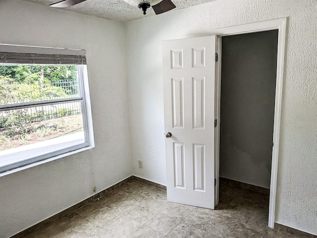 tiled empty room featuring ceiling fan