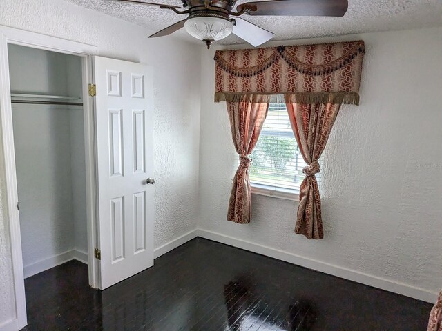 unfurnished bedroom featuring ceiling fan, wood-type flooring, a closet, and a textured ceiling