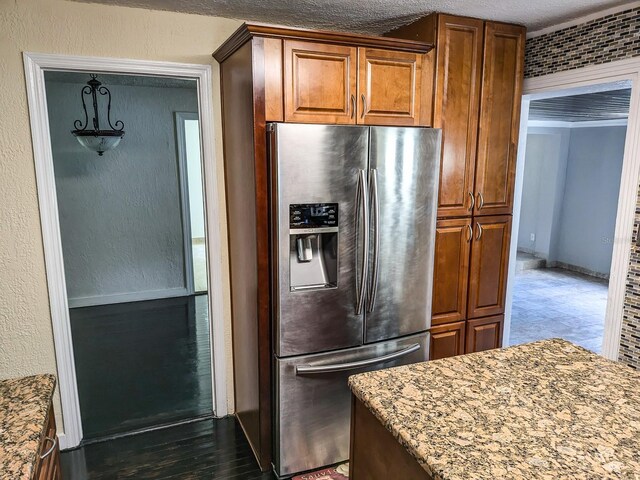 kitchen featuring light stone counters, stainless steel fridge with ice dispenser, and hardwood / wood-style flooring