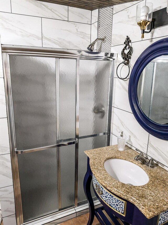 bathroom with sink, walk in shower, and tile walls