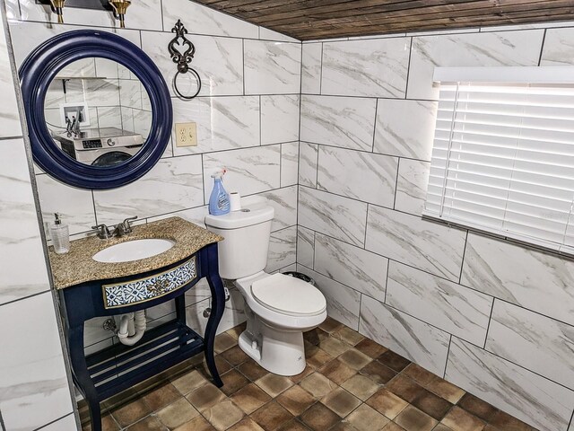 bathroom with sink, wood ceiling, toilet, and tile walls