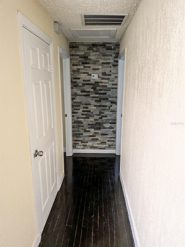 corridor with hardwood / wood-style flooring