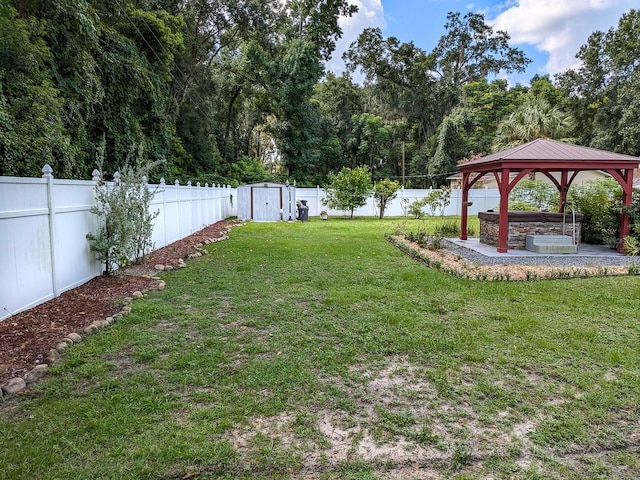 view of yard featuring a gazebo, a storage shed, and a patio