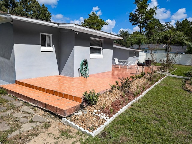 rear view of house featuring a lawn and a patio area