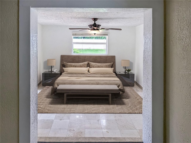 bedroom featuring ceiling fan and a textured ceiling