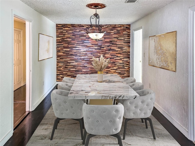 dining room with dark hardwood / wood-style flooring and a textured ceiling