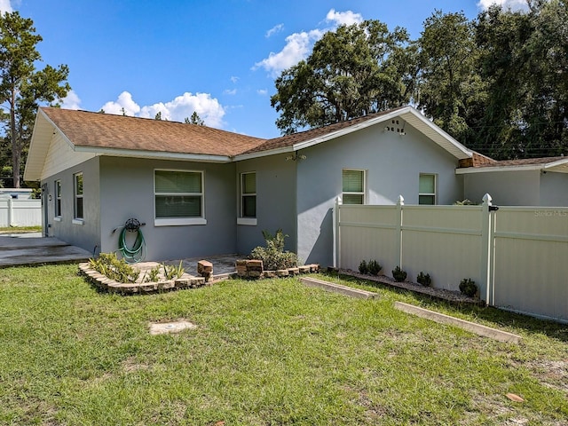 back of property with a patio area and a lawn