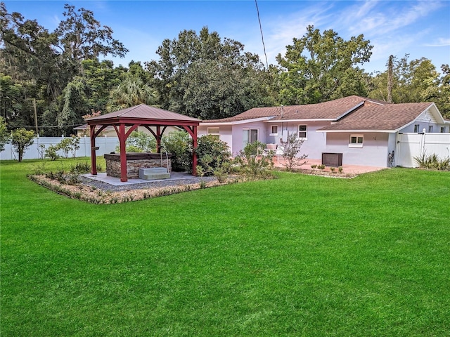 back of property with a yard and a gazebo