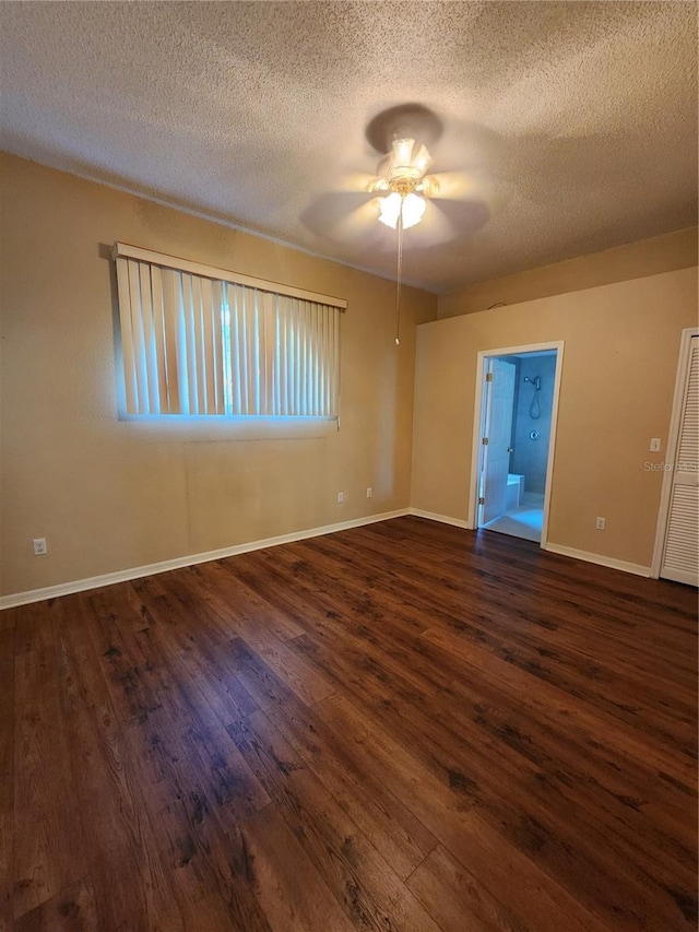 unfurnished room with dark wood-type flooring, a textured ceiling, baseboards, and a ceiling fan